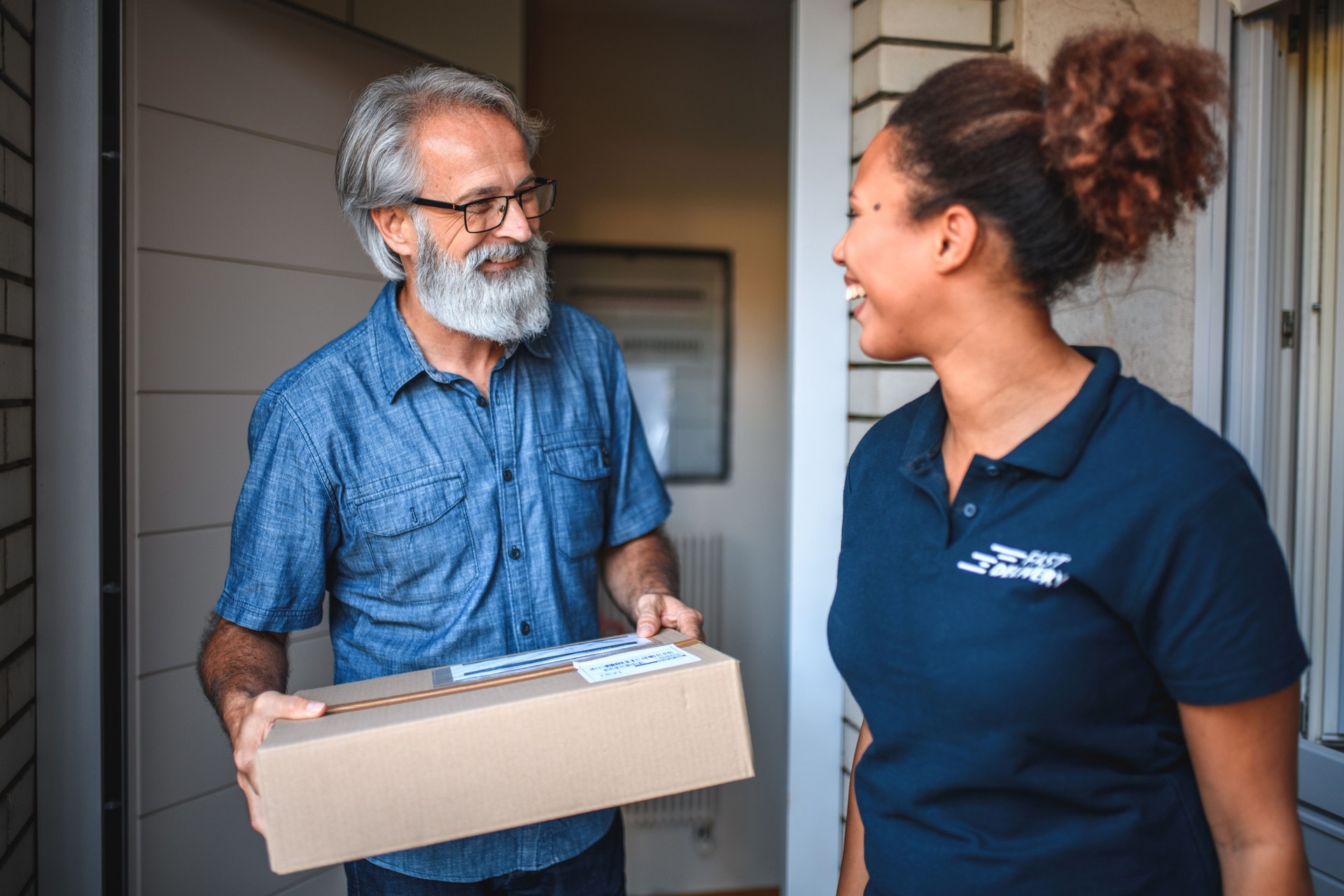 Young Delivery Woman Smiling And Handing Over A Box